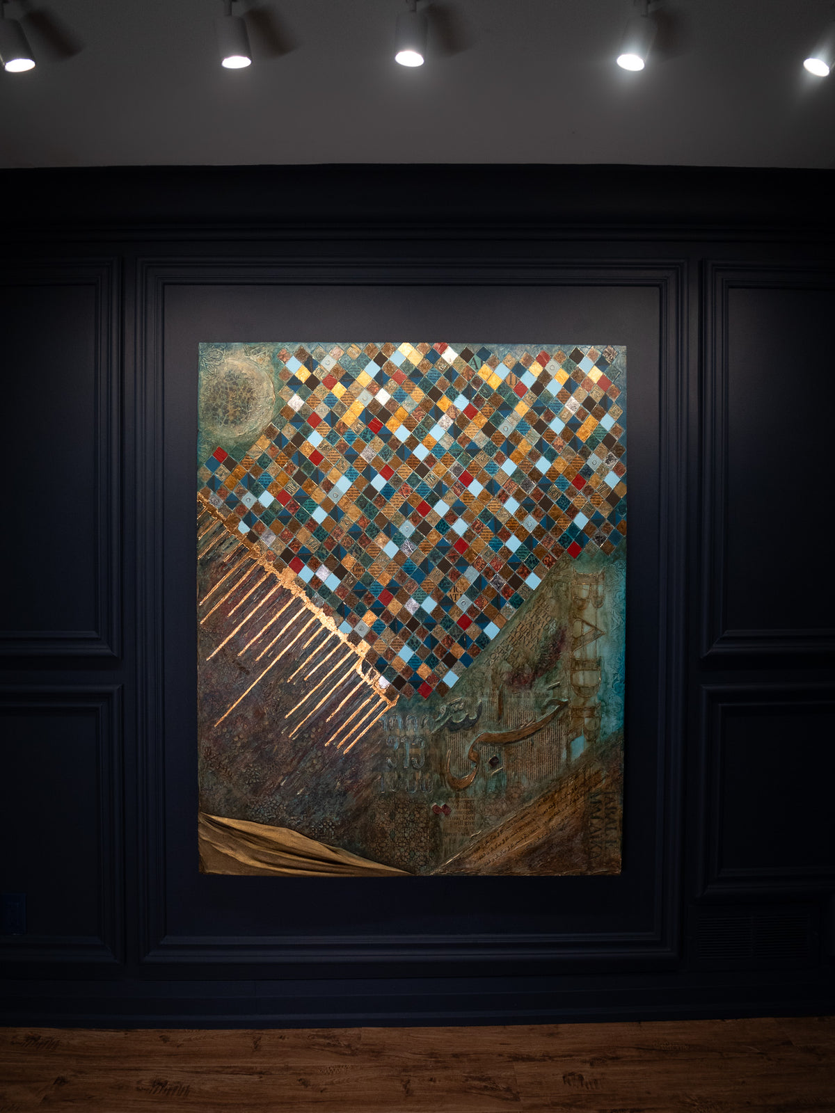 Battle of Badr original Seerah painting by Saleha: mosaic of gold, blue and red diamonds over a textured bronze panel, displayed in a dark gallery