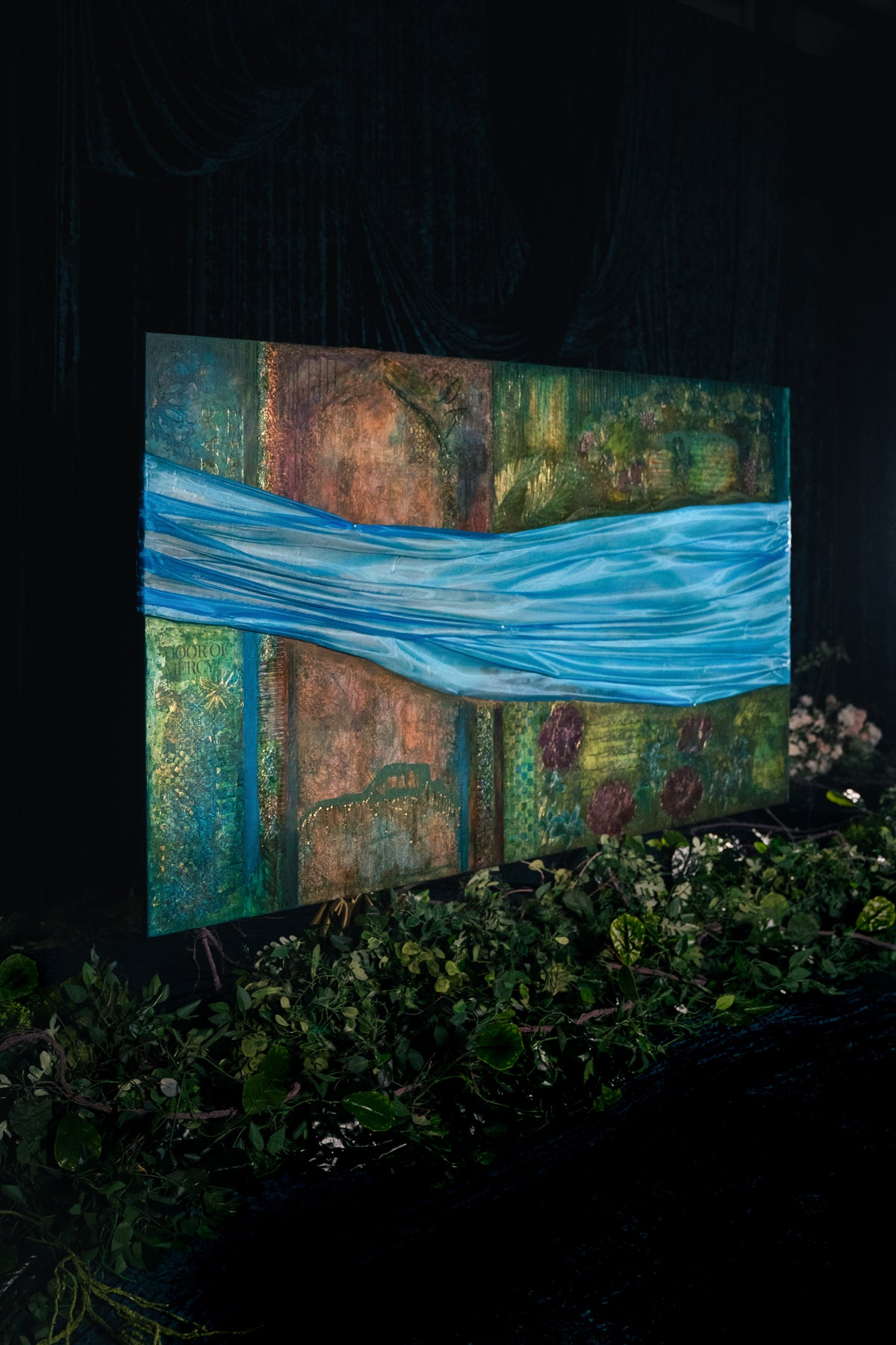 Breeze of Jannah original Islamic painting by Saleha: large canvas with a flowing blue fabric breeze over the gardens of Jannah, displayed at night