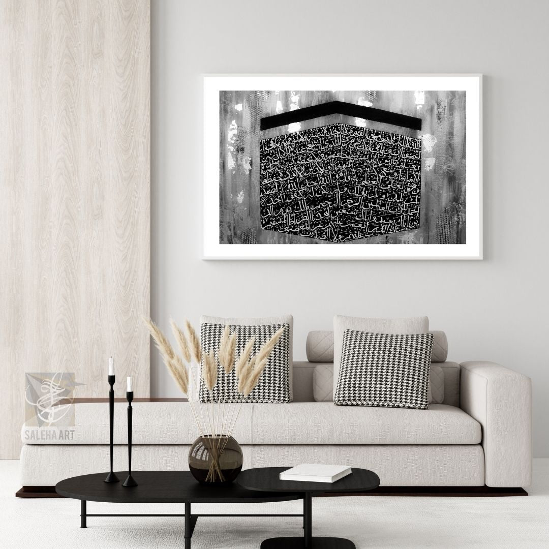 Black and white Ayatul Kursi Kaaba print above a white sofa, minimalist Islamic home decor