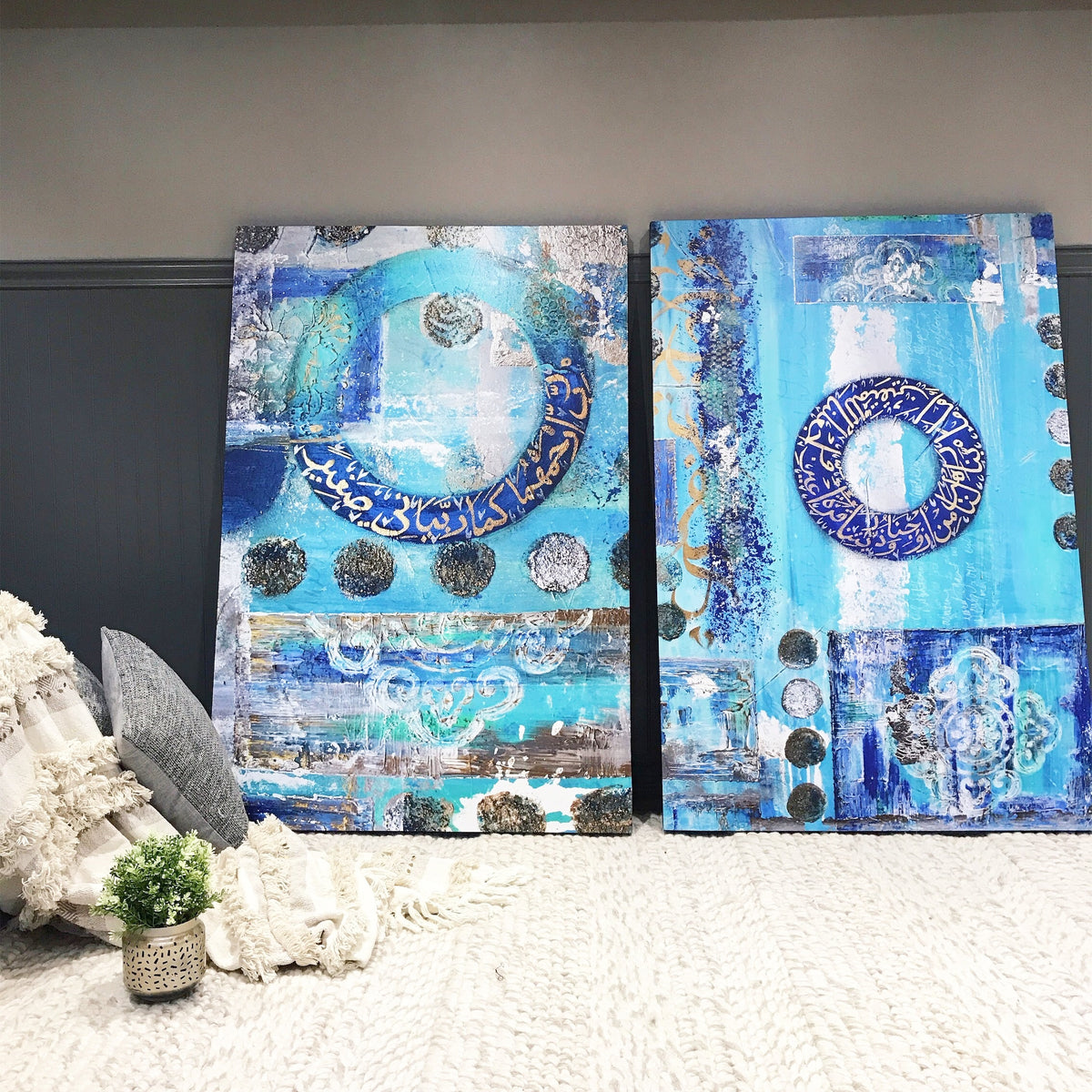 Blue and gold Dua for parents canvas pair leaning against a dark wall