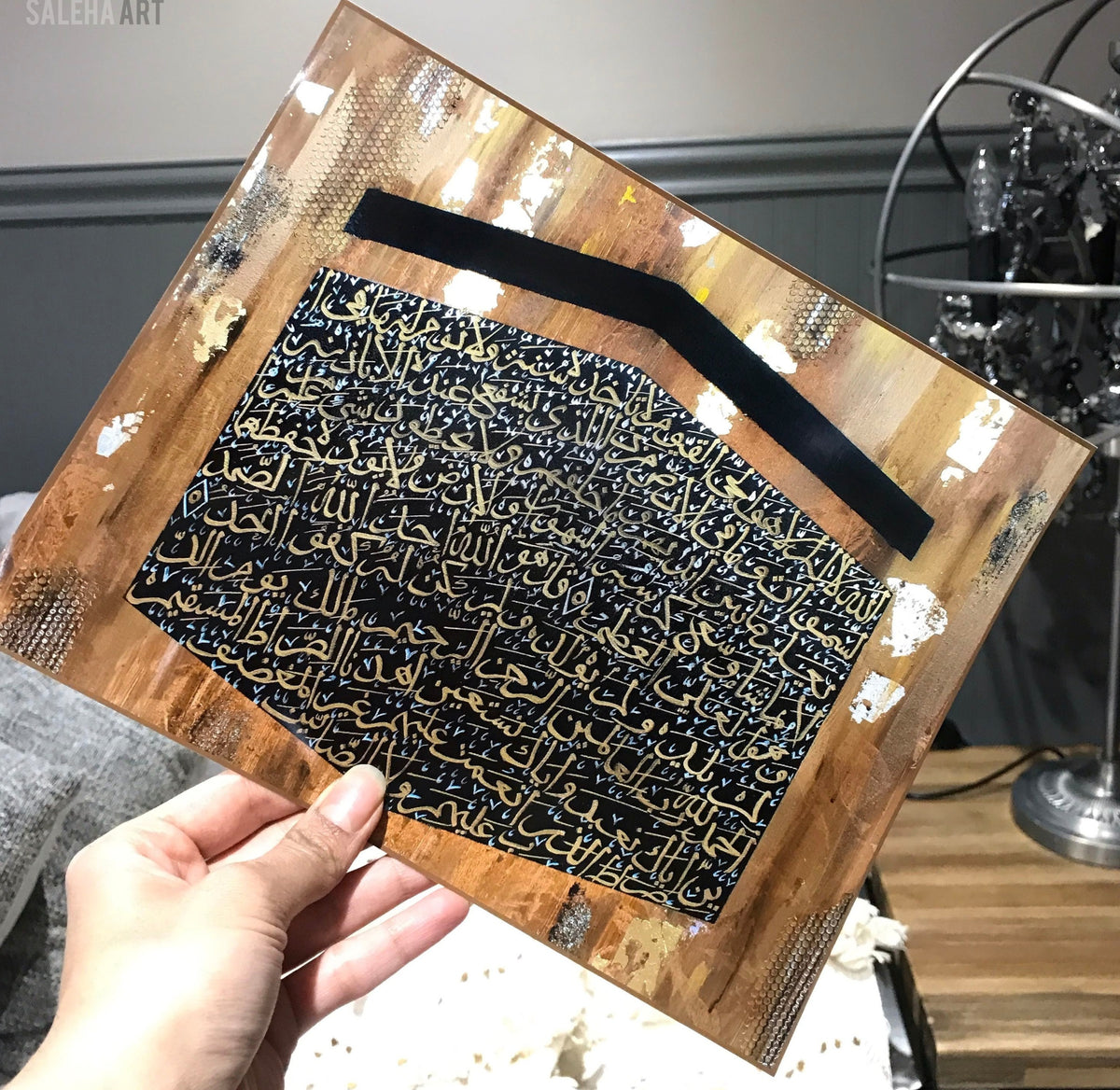 Angled view of the Kaaba canvas with gold and silver Quranic calligraphy