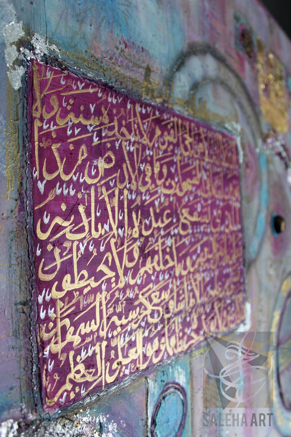 Close-up of pink and gold Ayatul Kursi calligraphy on the original painting